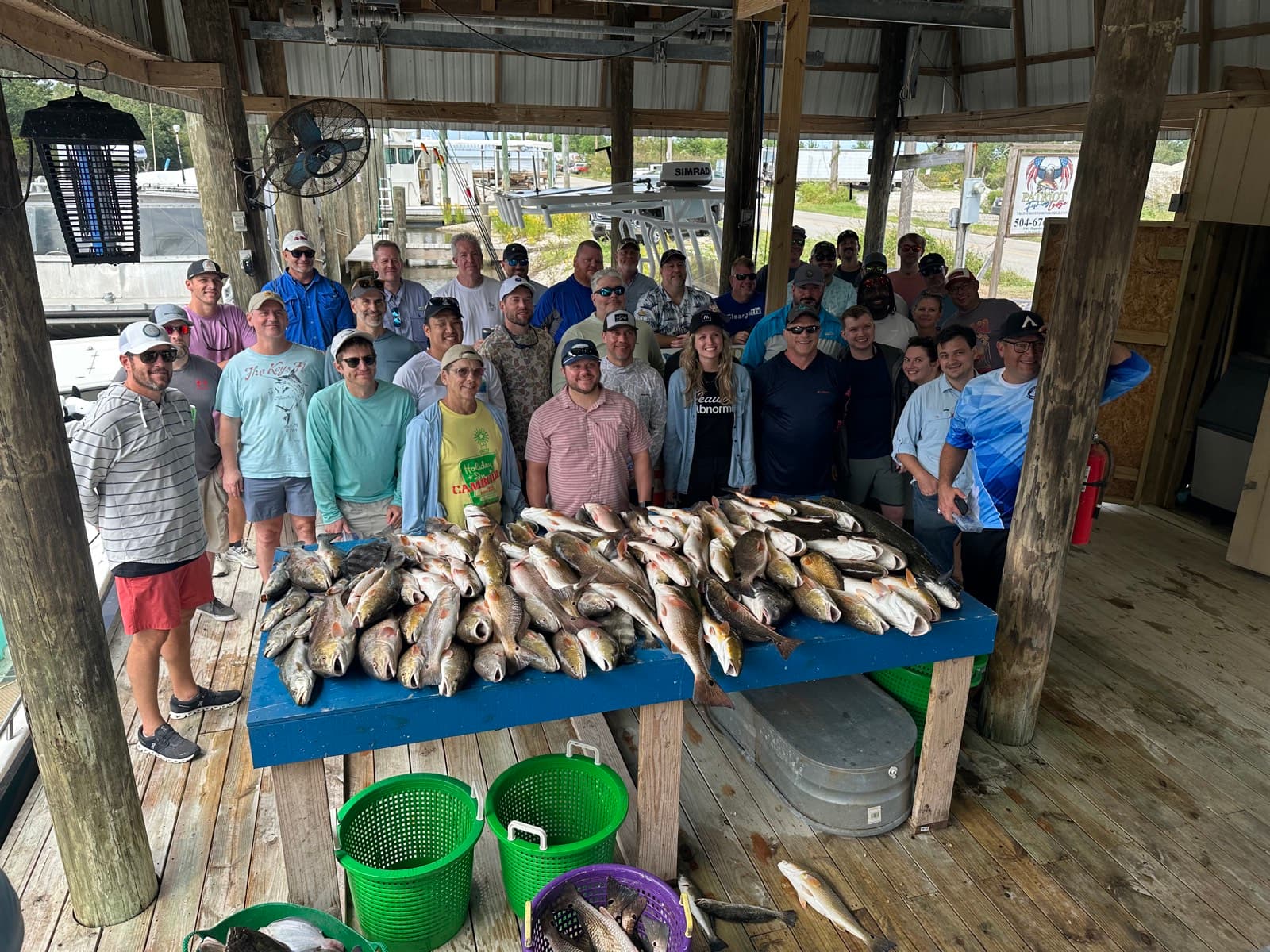 A large Hooked on Tails fishing group gathered behind the day's catch