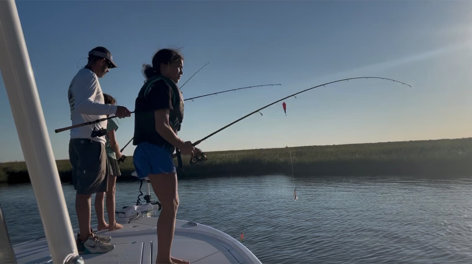 Anglers casting rods from the bow in a Louisiana marsh